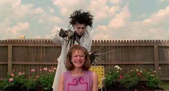 Movie still from “Edward Scissorhands” (1990), directed by Tim Burton – A woman standing next to a woman with a giant head; Medium shot, Over the shoulder angle