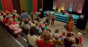 Movie still from “Edward Scissorhands” (1990), directed by Tim Burton – An audience watching a show on a television set; Wide shot, High angle