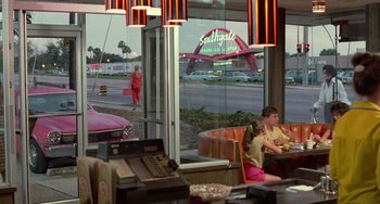 Movie still from “Edward Scissorhands” (1990), directed by Tim Burton – Two children are sitting at a table in front of a window; Wide shot, Over the shoulder angle
