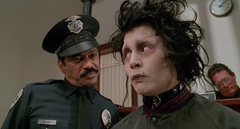 Movie still from “Edward Scissorhands” (1990), directed by Tim Burton – A police officer standing next to a woman in a wig; Close Up shot, Over the shoulder angle