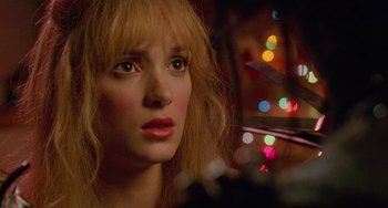 Movie still from “Edward Scissorhands” (1990), directed by Tim Burton – A woman's face with lights in the background; Close Up shot, Low angle