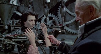 Movie still from “Edward Scissorhands” (1990), directed by Tim Burton – A man holding a pair of scissors in front of a mirror; Medium shot, Over the shoulder angle