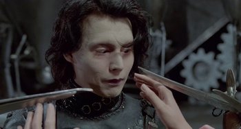 Movie still from “Edward Scissorhands” (1990), directed by Tim Burton – A person with makeup on their face; Close Up shot, Over the shoulder angle