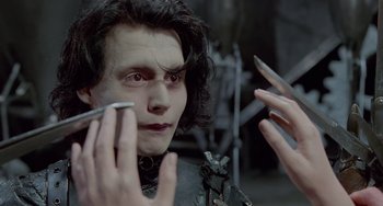 Movie still from “Edward Scissorhands” (1990), directed by Tim Burton – A person holding a cell phone; Close Up shot, Over the shoulder angle