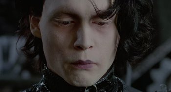 Movie still from “Edward Scissorhands” (1990), directed by Tim Burton – A person with long black hair; Close Up shot, Low angle