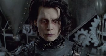 Movie still from “Edward Scissorhands” (1990), directed by Tim Burton – A person with long black hair; Close Up shot, Low angle