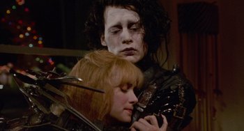 Movie still from “Edward Scissorhands” (1990), directed by Tim Burton – A man and a woman are holding each other in a room; Close Up shot, Low angle