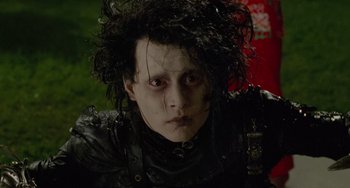 Movie still from “Edward Scissorhands” (1990), directed by Tim Burton – A person wearing a black shirt; Close Up shot, Low angle