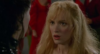 Movie still from “Edward Scissorhands” (1990), directed by Tim Burton – A person with long blonde hair; Close Up shot, Over the shoulder angle