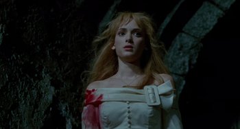 Movie still from “Edward Scissorhands” (1990), directed by Tim Burton – A woman in a white dress with blood on her arm; Medium shot, Low angle