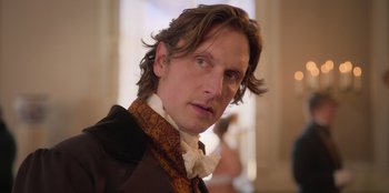 Movie still from “Ehrengard: The Art of Seduction” (2023), directed by Bille August – A person with long hair; Close Up shot, Over the shoulder angle