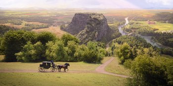 Movie still from “Ehrengard: The Art of Seduction” (2023), directed by Bille August – A horse drawn carriage traveling down a road near a mountain; Extreme Wide shot, High angle