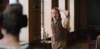 Movie still from “Ehrengard: The Art of Seduction” (2023), directed by Bille August – A man with a surprised look on his face; Close Up shot, Over the shoulder angle