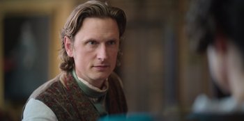 Movie still from “Ehrengard: The Art of Seduction” (2023), directed by Bille August – A person with long brown hair; Close Up shot, Over the shoulder angle