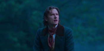 Movie still from “Ehrengard: The Art of Seduction” (2023), directed by Bille August – A man wearing a suit and a neck tie; Close Up shot, Low angle