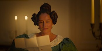 Movie still from “Ehrengard: The Art of Seduction” (2023), directed by Bille August – A woman in a green dress holding an open envelope; Close Up shot, Over the shoulder angle