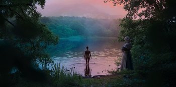 Movie still from “Ehrengard: The Art of Seduction” (2023), directed by Bille August – A man standing in the water next to a woman; Extreme Wide shot, High angle