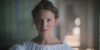 Movie still from “Ehrengard: The Art of Seduction” (2023), directed by Bille August – A beautiful young lady wearing a white dress; Close Up shot, Low angle