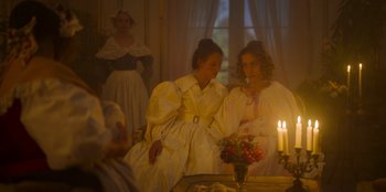 Movie still from “Ehrengard: The Art of Seduction” (2023), directed by Bille August – Two women in white dresses sitting in front of a mirror; Medium shot, Over the shoulder angle