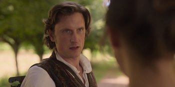 Movie still from “Ehrengard: The Art of Seduction” (2023), directed by Bille August – A man in a vest looking at another man in a vest; Close Up shot, Over the shoulder angle