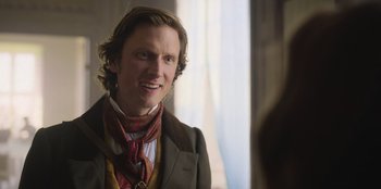 Movie still from “Ehrengard: The Art of Seduction” (2023), directed by Bille August – A man wearing a suit and a neck tie; Close Up shot, Over the shoulder angle