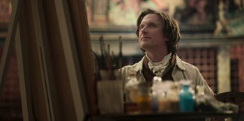 Movie still from “Ehrengard: The Art of Seduction” (2023), directed by Bille August – A man looking at a painting in a room; Medium shot, Low angle