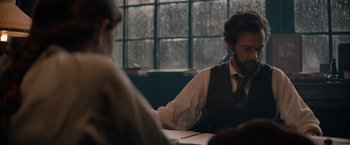 Movie still from “Eiffel” (2021), directed by Martin Bourboulon – A man sitting at a table in front of another man; Medium shot, Over the shoulder angle