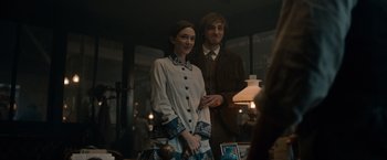 Movie still from “Eiffel” (2021), directed by Martin Bourboulon – A man and a woman standing next to each other in a room; Medium shot, Over the shoulder angle