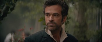 Movie still from “Eiffel” (2021), directed by Martin Bourboulon – A person wearing a jacket; Close Up shot, Over the shoulder angle