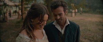 Movie still from “Eiffel” (2021), directed by Martin Bourboulon – A man and a woman standing next to each other in front of a tree; Close Up shot, Over the shoulder angle
