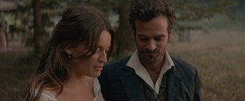 Movie still from “Eiffel” (2021), directed by Martin Bourboulon – A man and a woman standing next to each other in front of a tree; Close Up shot, Over the shoulder angle