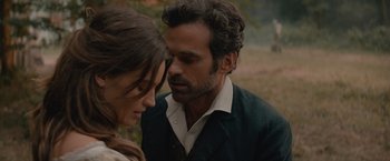 Movie still from “Eiffel” (2021), directed by Martin Bourboulon – A man and a woman standing next to each other in a field; Close Up shot, Over the shoulder angle