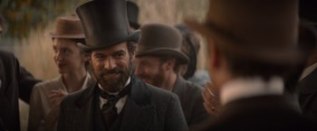 Movie still from “Eiffel” (2021), directed by Martin Bourboulon – A man with a beard wearing a top hat; Close Up shot, Over the shoulder angle
