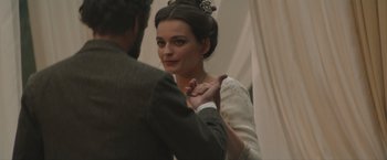 Movie still from “Eiffel” (2021), directed by Martin Bourboulon – A man and a woman holding hands in a room; Close Up shot, Over the shoulder angle