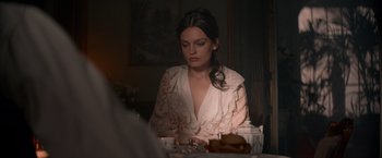 Movie still from “Eiffel” (2021), directed by Martin Bourboulon – A woman sitting at a table with a cup of coffee; Medium shot, Over the shoulder angle