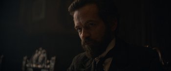 Movie still from “Eiffel” (2021), directed by Martin Bourboulon – A man with a beard is looking at the camera; Close Up shot, Over the shoulder angle