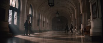 Movie still from “Eiffel” (2021), directed by Martin Bourboulon – People are walking in a large hallway with a light fixture hanging from the ceiling; Extreme Wide shot, High angle