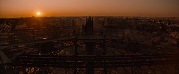 Movie still from “Eiffel” (2021), directed by Martin Bourboulon – A view of a city from above at sunset; Extreme Wide shot, Low angle