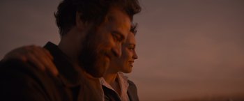 Movie still from “Eiffel” (2021), directed by Martin Bourboulon – A man and a woman smiling for the camera; Close Up shot, Over the shoulder angle