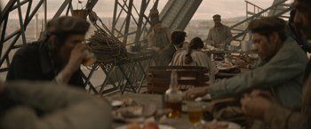 Movie still from “Eiffel” (2021), directed by Martin Bourboulon – A group of people sitting around a table; Wide shot, Over the shoulder angle