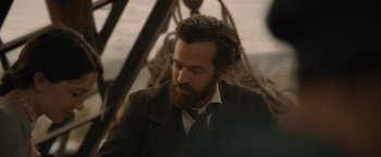 Movie still from “Eiffel” (2021), directed by Martin Bourboulon – A man with a beard and a suit and tie; Close Up shot, Over the shoulder angle