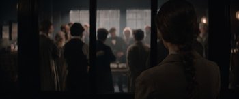 Movie still from “Eiffel” (2021), directed by Martin Bourboulon – A group of people standing in front of a window; Medium shot, Over the shoulder angle