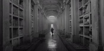 Movie still from “El Conde” (2023), directed by Pablo Larraín – A person walking down a hallway in an abandoned building; Wide shot, Low angle