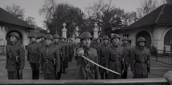 Movie still from “El Conde” (2023), directed by Pablo Larraín – A group of men in uniforms are standing in a line; Wide shot, Low angle
