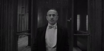 Movie still from “El Conde” (2023), directed by Pablo Larraín – A black and white photo of a man in a tuxedo; Medium shot, Low angle