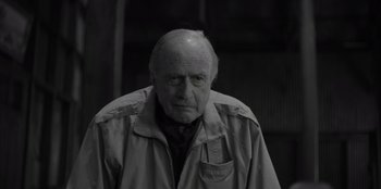 Movie still from “El Conde” (2023), directed by Pablo Larraín – An older man wearing a jacket and a hat; Close Up shot, Over the shoulder angle