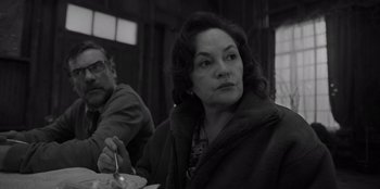Movie still from “El Conde” (2023), directed by Pablo Larraín – A woman sitting at a table with a man in the background; Close Up shot, Over the shoulder angle