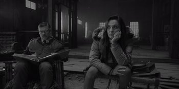 Movie still from “El Conde” (2023), directed by Pablo Larraín – A woman sitting on the ground with her head resting on her hands; Medium shot, Over the shoulder angle