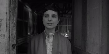 Movie still from “El Conde” (2023), directed by Pablo Larraín – A woman with short dark hair standing in front of a building; Close Up shot, Low angle