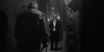 Movie still from “El Conde” (2023), directed by Pablo Larraín – A black and white photo of a man in a suit; Wide shot, Over the shoulder angle